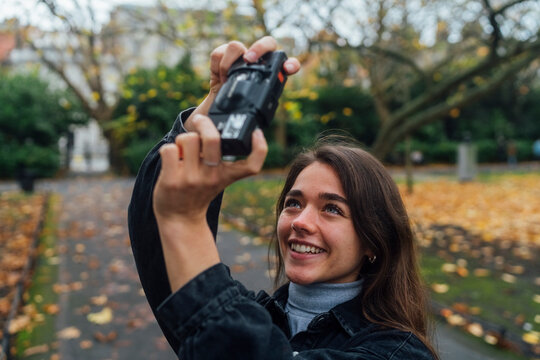 Woman taking Pictures of Autumn with an Old Camera