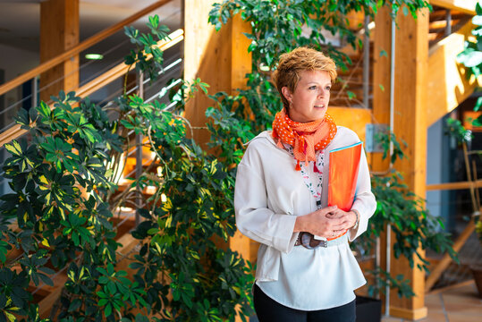 Adult serious businesswoman holding red folder