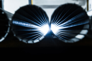 Stack of metallic tubes backlit by the flash