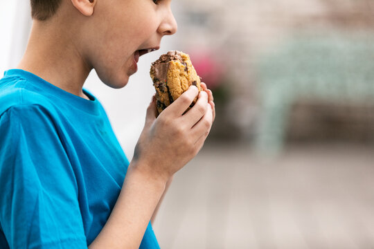 Boy Taking A Big Bite Of Ice Cream Cookie