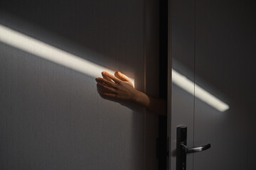 The hand from the door touches the beam of light
