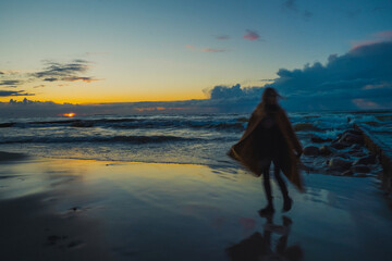 Woman at sunset by the sea