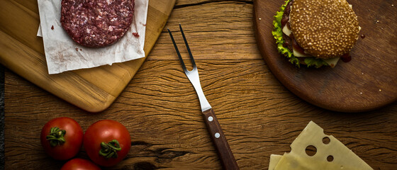 rustic wood with meat hamburger fork and tomatoes