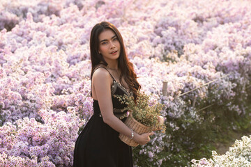 Portrait of a woman stands in a field of pink cutter flowers