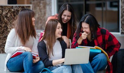 Group of four young attractive asian girls college students studying together using laptop in university campus outdoor. Concept for education, friendship and college students life