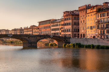 Fototapeta premium Florence, Italy -20 June, 2019 : view of St Trinity Bridge, river Arno and residential area of the city at golden hour.