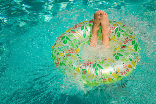 Pre Teen Girl Swimming and Jumping on a Floatie in the Pool