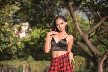 A young and confident young Filipina in a black spaghetti strap top exposing her midriff. Weekend...