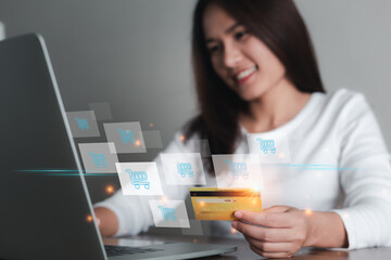 Fototapeta premium Asian woman holding credit card and using laptop computer with icon shopping cart, Online shopping, e-commerce, internet banking, spending money, Online payment concept.