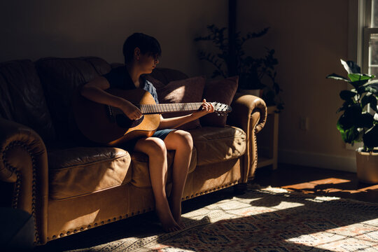 boy playing guitar in living room
