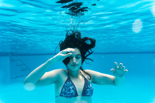 Crop of woman wearing bikini swimming underwater