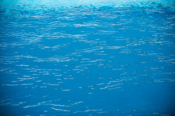 Ripple Water in swimming pool with sun reflection. Wavy water background.