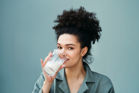 A young positive woman with glass of milk.