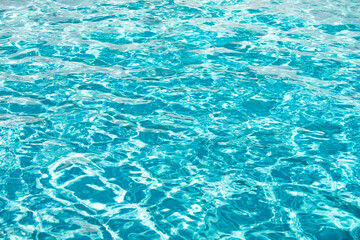 Ripple Water in swimming pool with sun reflection. Wavy water background.