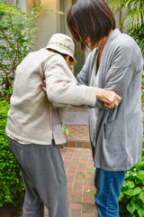 高齢者の女性を支える介護者。A caregiver who supports elderly women.