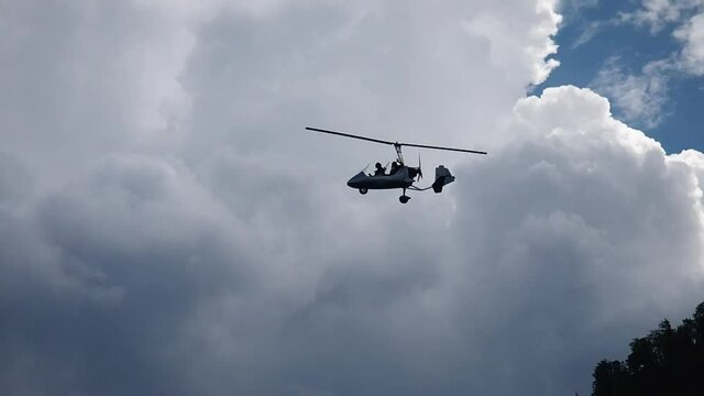 Gyroplane flying in the sky over lake Attersee, Austria.