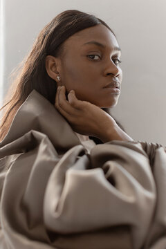 Trendy Black Woman wearing a brown blouse in Studio