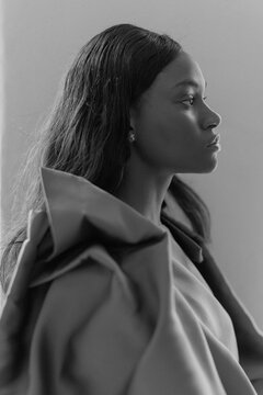 Trendy Black Woman wearing a brown blouse in Studio