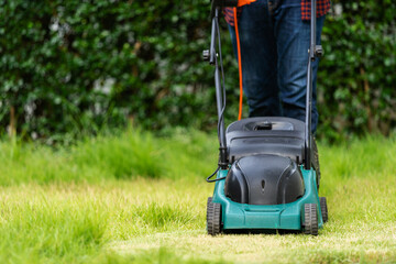 worker using a lawn mower cutting grass
