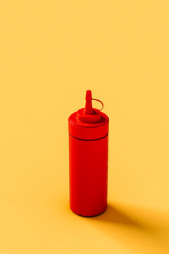 one red Sauce dispencer on yello background