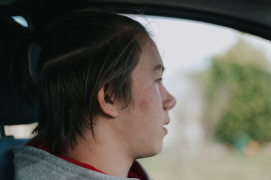 A young man in a car looking to the road