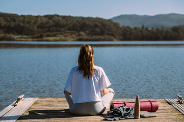 Unrecognizable woman doing yoga on wooden pier