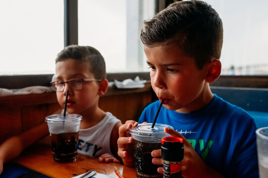 Children sitting in a booth at a restaurant. 