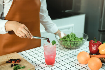 Asian woman is decorating a cocktail glass.