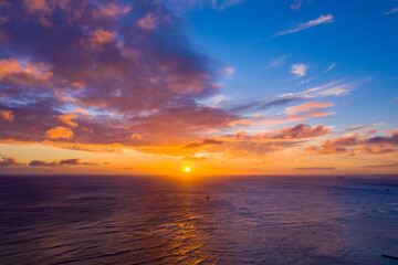 Fototapeta na wymiar Sun setting over the Pacific Ocean as seen from Waikiki Beach 