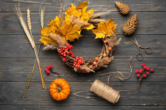 Beautiful autumn wreath with craft supplies on wooden background