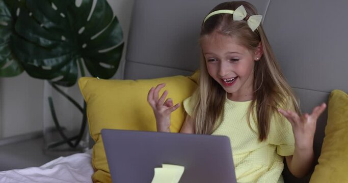 Caucasian little girl school pupil studying online from home, watching web class lesson or listening tutor by video call elearning during coronavirus covid-19 pandemic self isolation. Slow motion