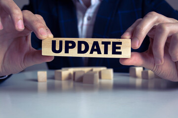 Close up Hand of a Businessman Arranging Small Wooden Blocks with update words on block