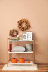 Shelving unit with autumn decor in interior of room