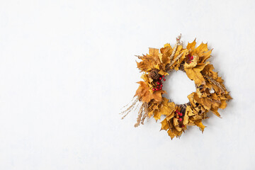 Beautiful autumn wreath hanging on white wall