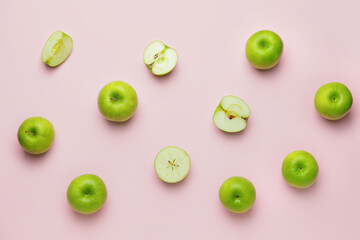 Fresh green apples with pieces on color background