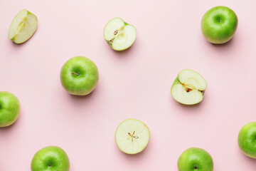 Fresh green apples with pieces on color background