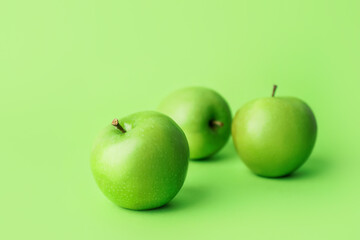 Fresh green apples on color background