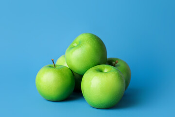 Fresh green apples on color background