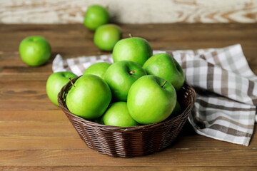 Basket with fresh green apples on table