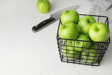 Basket with fresh green apples on table