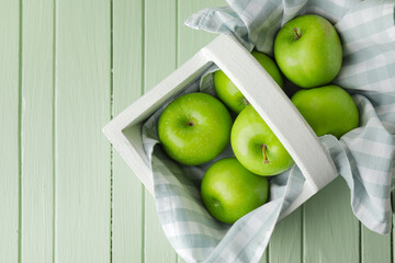 Basket with fresh green apples on table