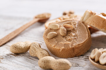 Bread with tasty peanut butter on table