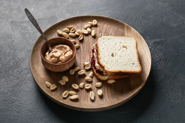 Tray with tasty peanut sandwich on dark background