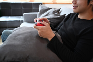 Young man playing video games on sofa.