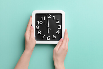 Female hands with stylish clock on color background, closeup