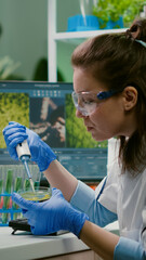 Chemist woman taking dna liquid from test tube with micropipette putting in petri dish analyzing...