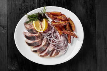 Salted herring with fried potato wedges, onion, lemon