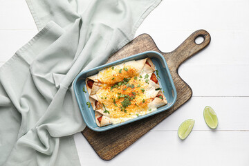 Baking dish with tasty cooked enchilada on table