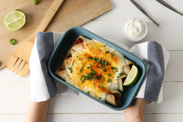 Woman with hot enchilada in baking dish