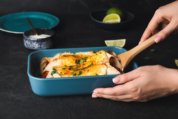 Woman with hot enchilada in baking dish